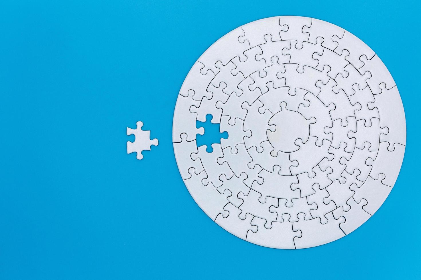 unfertige weiße Puzzleteile auf blauem Hintergrund, das letzte Puzzle des Erfolgs. foto