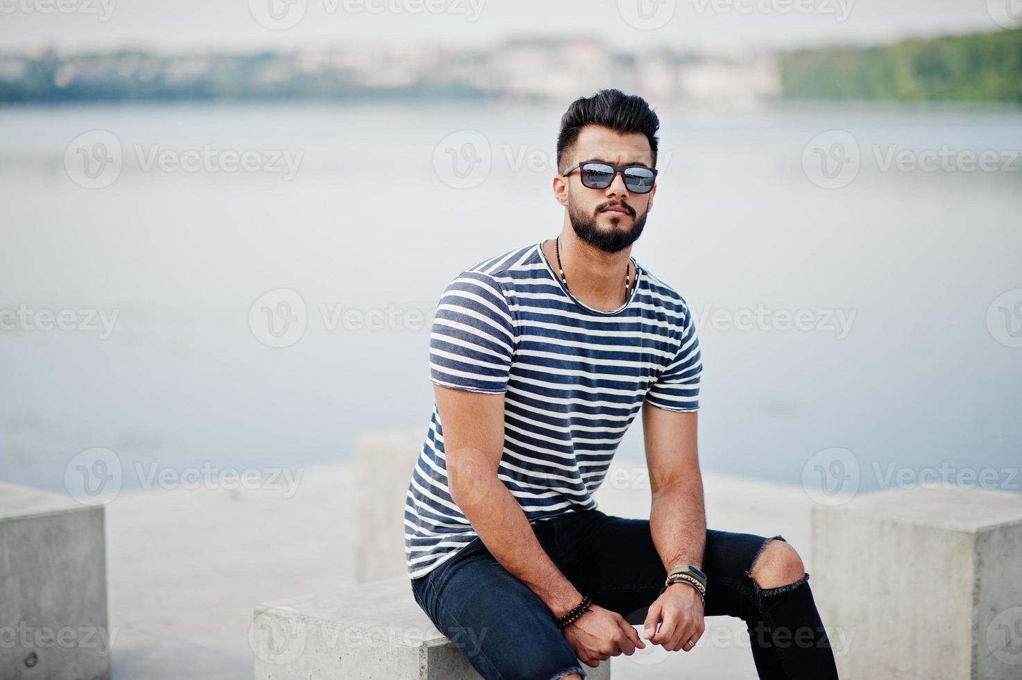 gutaussehender großer arabischer bartmannmodell im abgestreiften hemd posierte im freien. Modischer arabischer Typ mit Sonnenbrille. foto