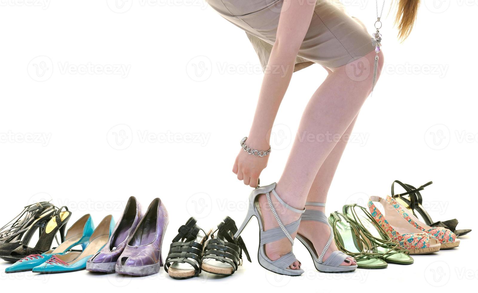 hübsche junge Frau mit Schuhe Kaufsucht, isoliert auf weißem Hintergrund foto