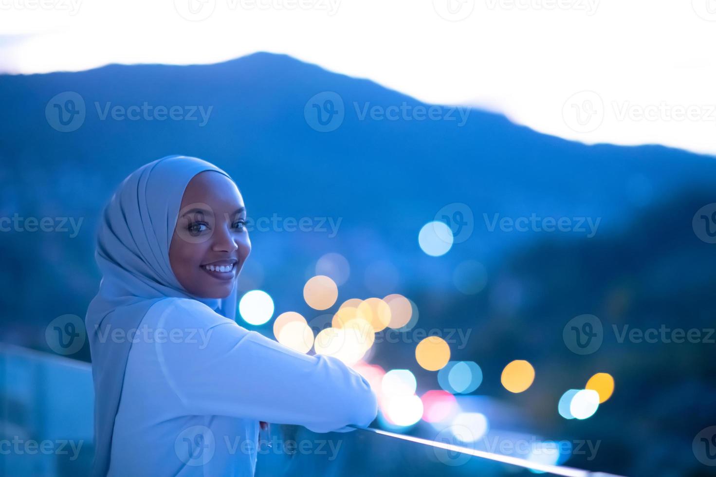 afrikanische moderne muslimische frau in der nacht auf dem balkon foto