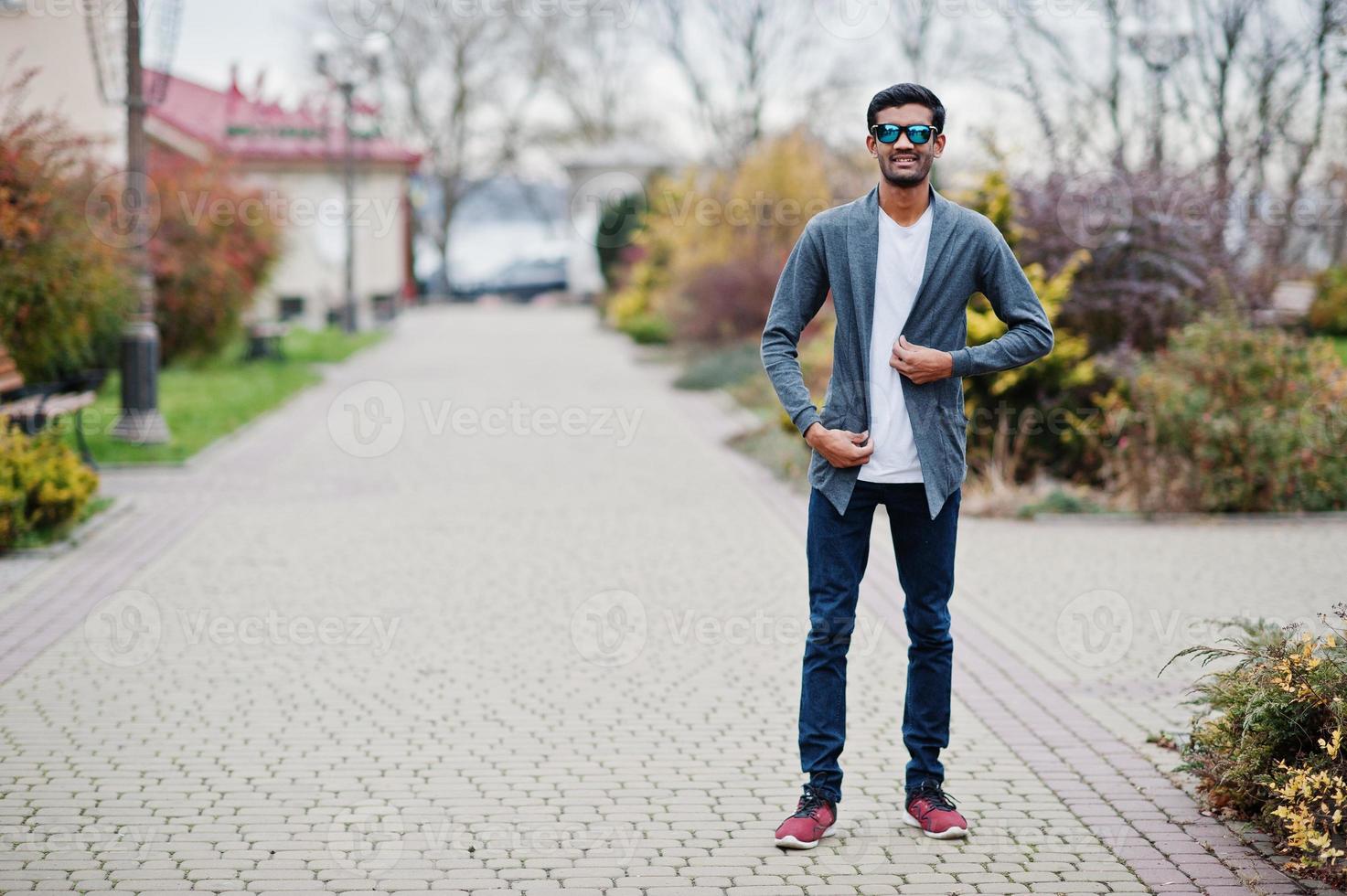 Stilvoller indischer Mann mit Sonnenbrille trägt lässige Posen im Freien. foto