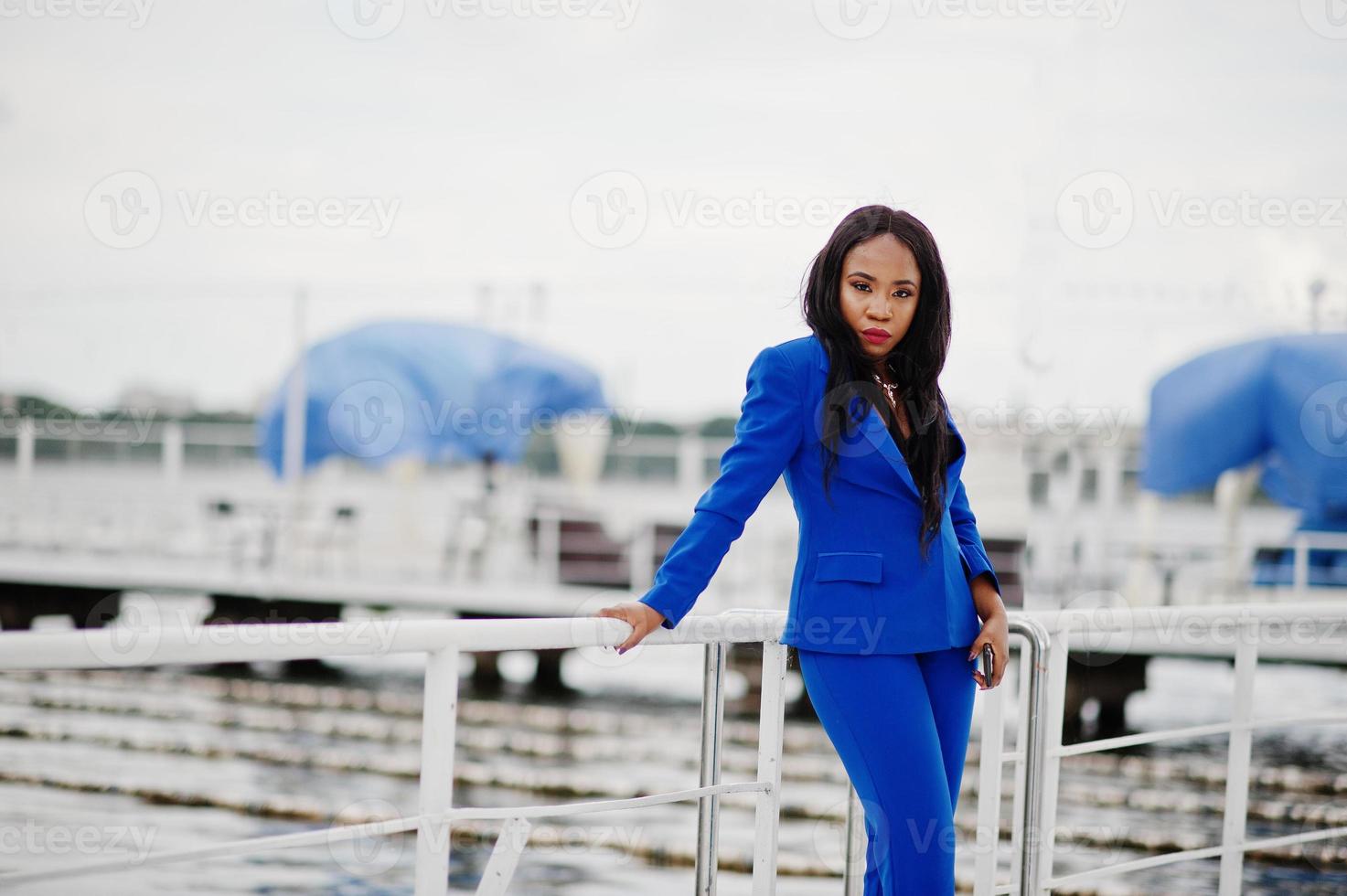 Erfolg afroamerikanische Geschäftsfrau im blauen Anzug mit Handy. foto