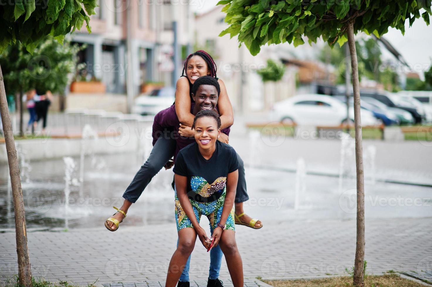 drei afroamerikanische freunde, die zusammen spaß haben. auf die Schulter springen. foto