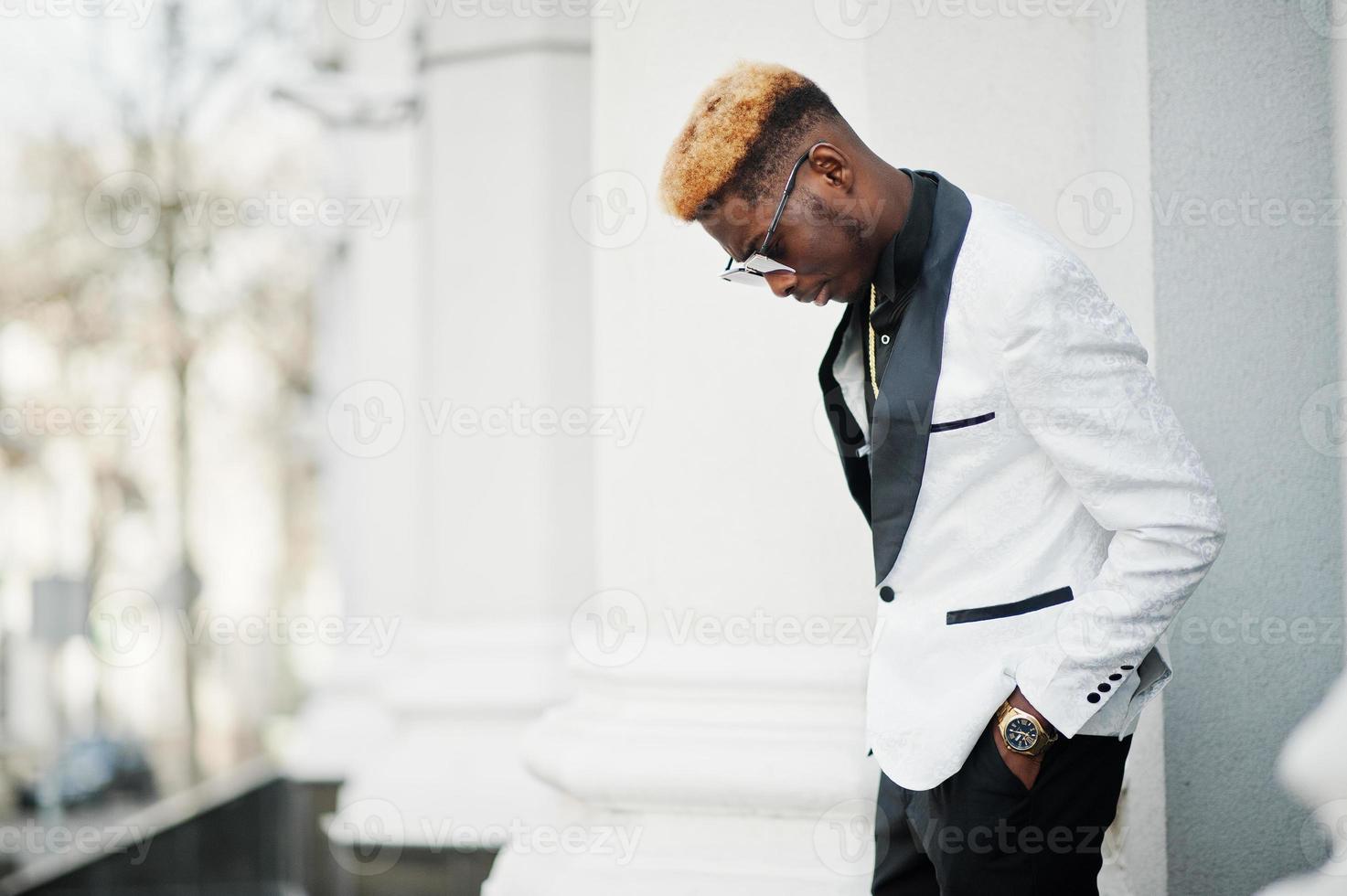 schicker gutaussehender afroamerikanischer mann in weißem anzug und sonnenbrille. foto