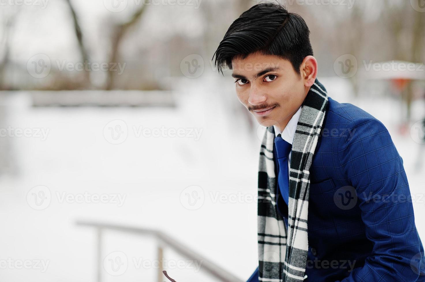 stilvoller indischer studentenmann in anzug und schal posierte am wintertag im freien. foto
