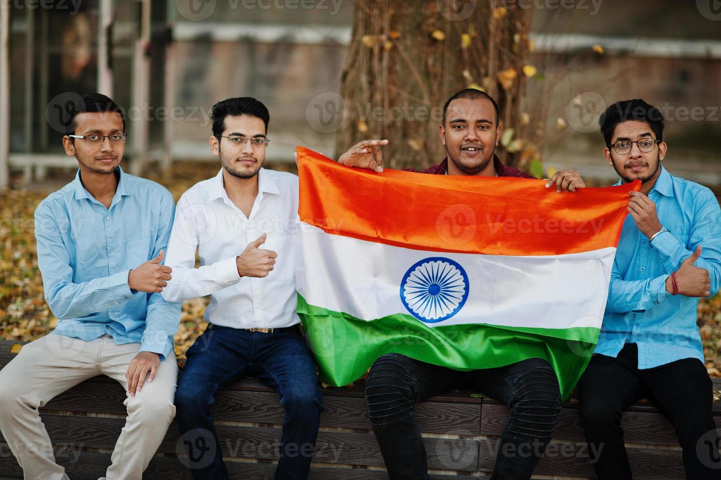 Gruppe von vier südasiatischen indischen Männchen mit Indien-Flagge. foto