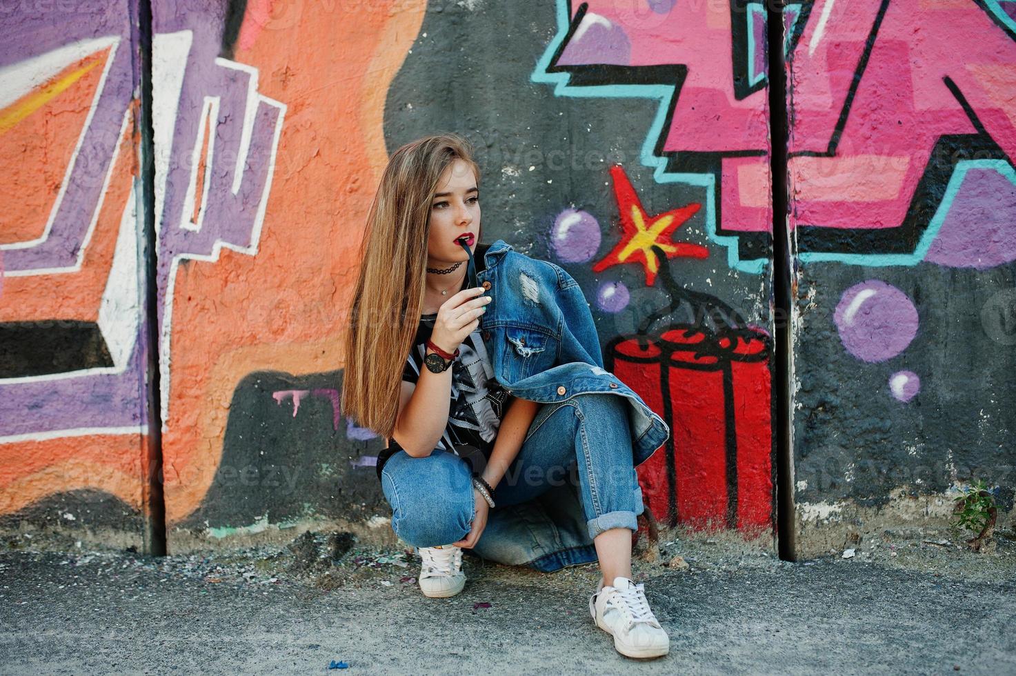 stylisches, lässiges Hipster-Mädchen in Jeans und Brille gegen große Graffiti-Wand. foto