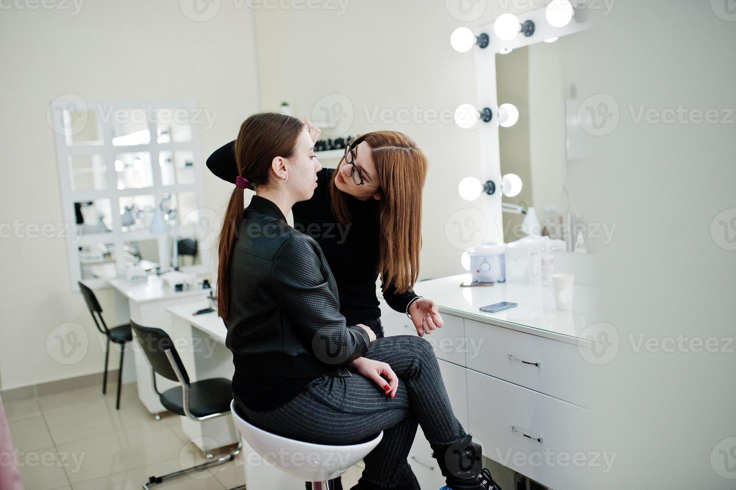 Make-up-Künstlerarbeit in ihrem Beauty-Visage-Studio-Salon. frau, die sich von einem professionellen make-up-meister bewirbt. Beauty-Club-Konzept. foto