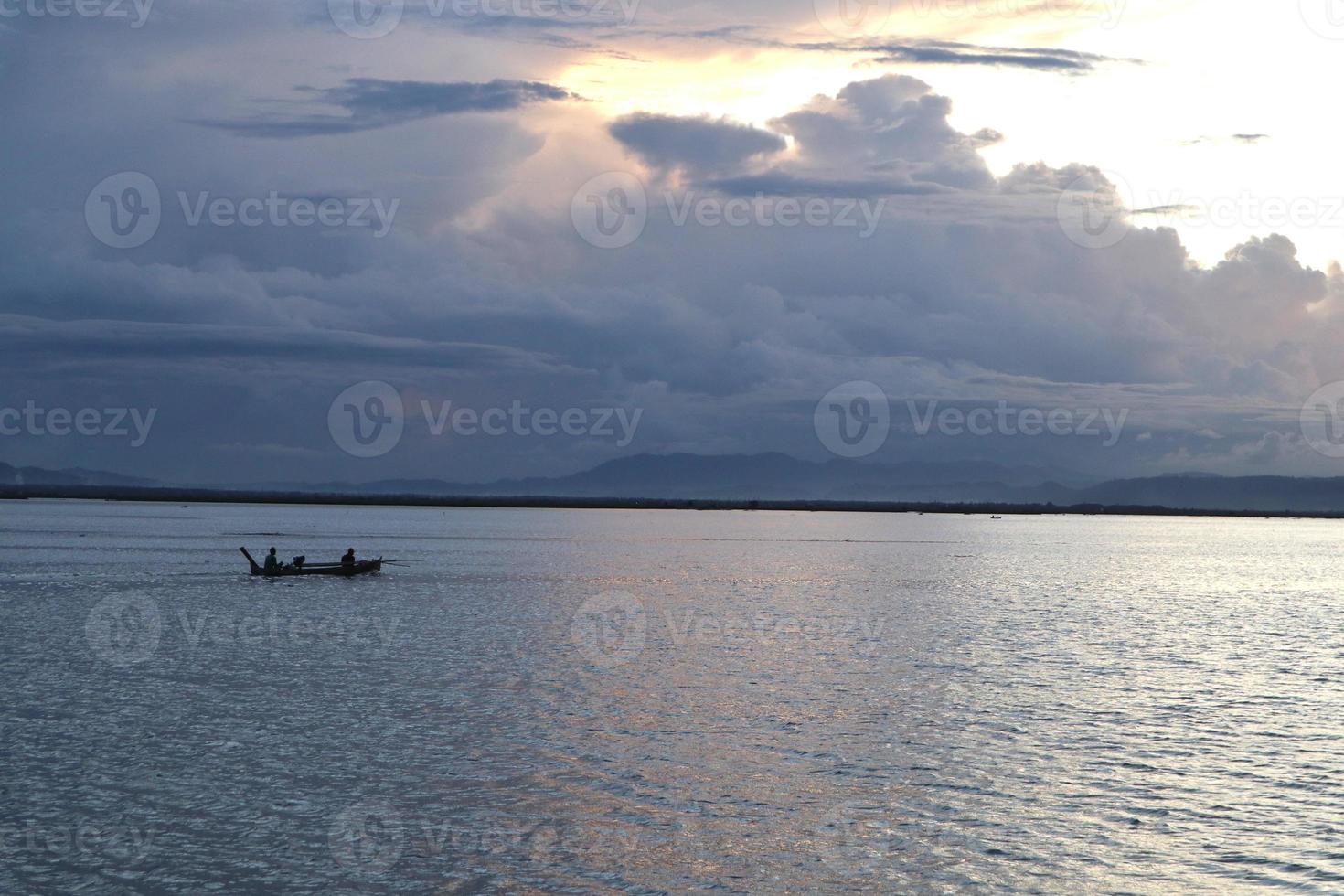 Fischer auf seinem Boot bei Sonnenuntergang. Fischerboot bei Sonnenuntergang foto