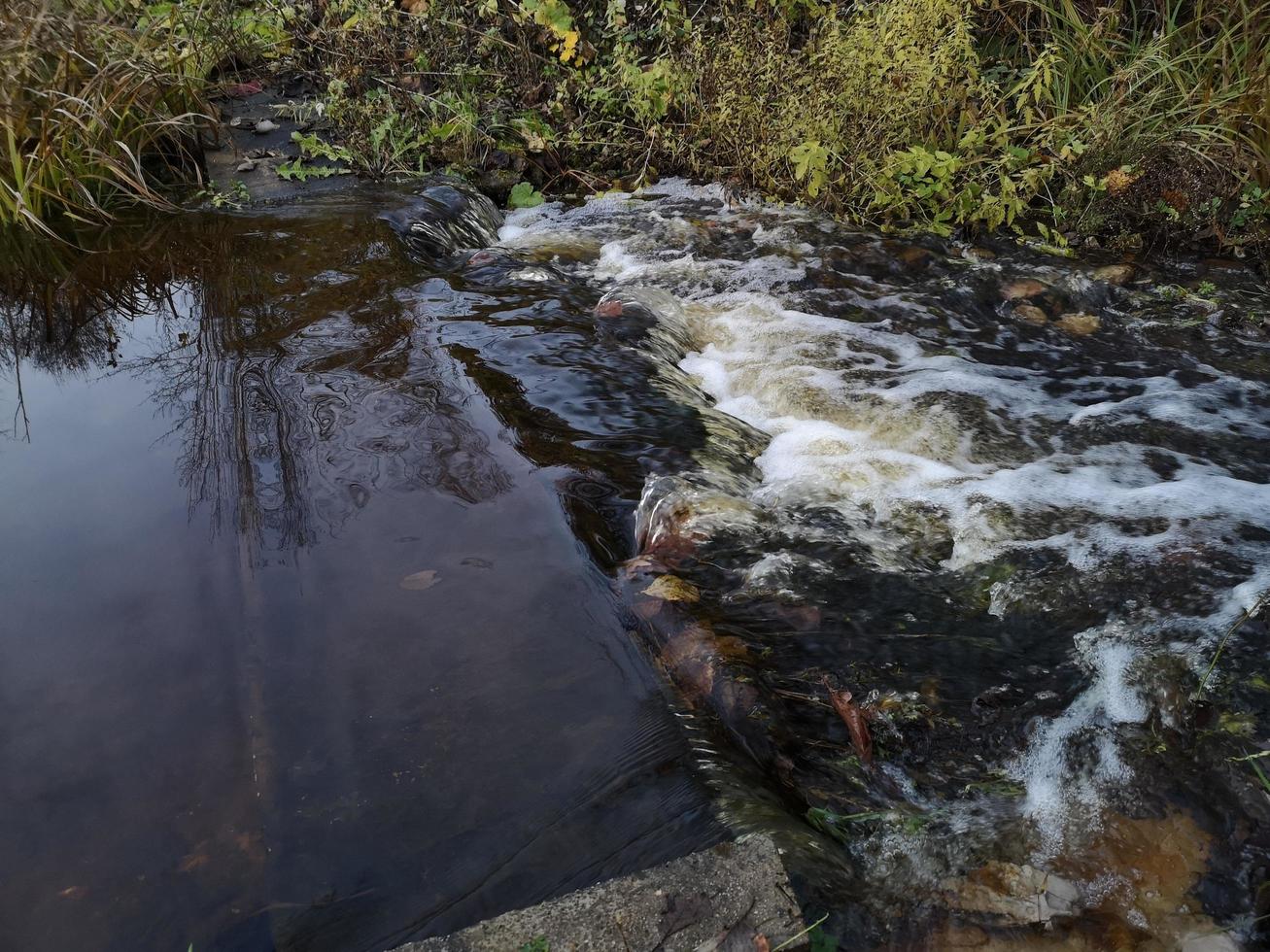 starke Strömung an einem kleinen Fluss. Stromschnellen auf dem Wasser foto