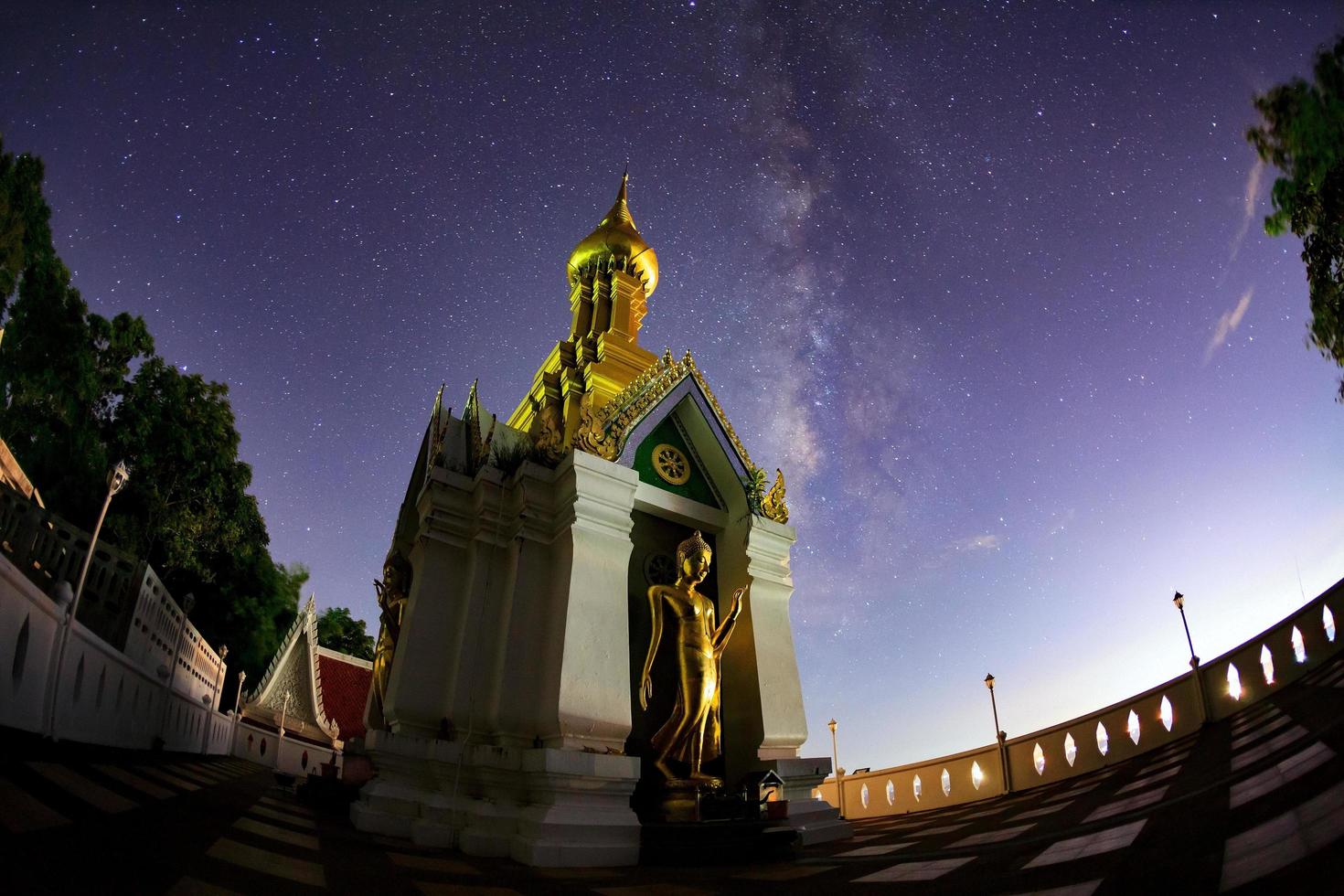 Milchstraße am Standing Gold Buddha Bildname ist Wat Sra Song Pee Nong in Phitsanulok, Thailand foto