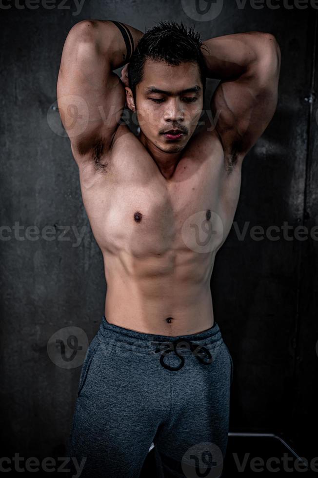 porträt des asiatischen mannes großer muskel im fitnessstudio, thailänder, training für gute gesunde, körpergewichtstraining, fitness im fitnessstudio-konzept foto