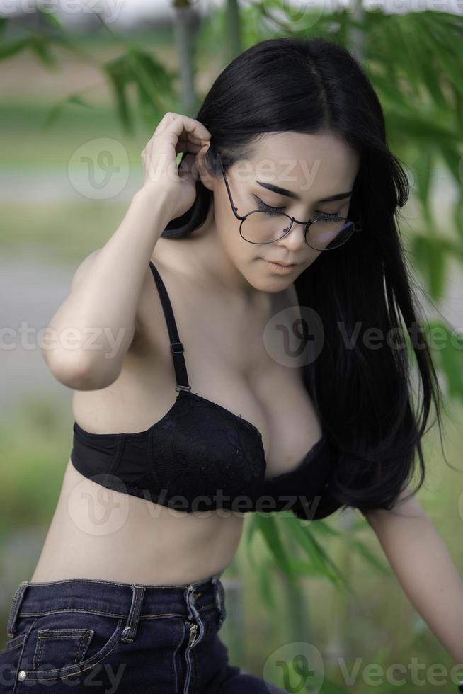 porträt einer sexy asiatischen frau, die einen schwarzen bh auf dem feld trägt, thailänder machen ein foto