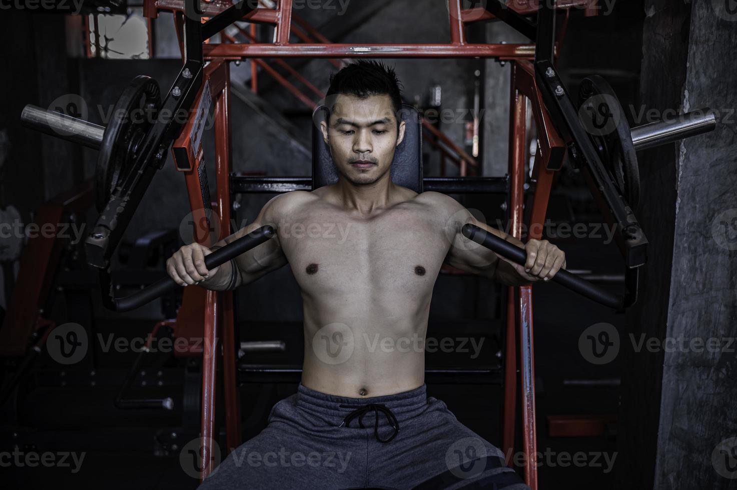 porträt des asiatischen mannes großer muskel im fitnessstudio, thailänder, training für gute gesunde, körpergewichtstraining, fitness im fitnessstudio-konzept foto