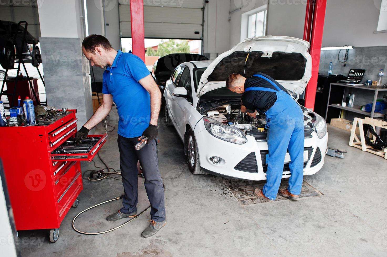 Thema Autoreparatur und -wartung. Mechaniker in Uniform, der im Autoservice arbeitet. foto