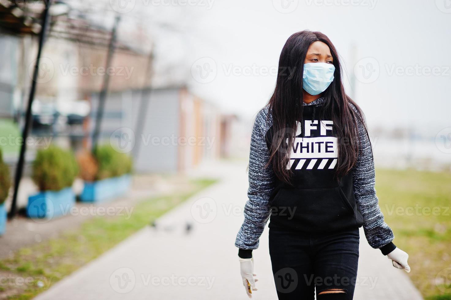 afrikanisches mädchen im park, das medizinische masken trägt, schützt vor infektionen und krankheiten coronavirus-virus-quarantäne. foto