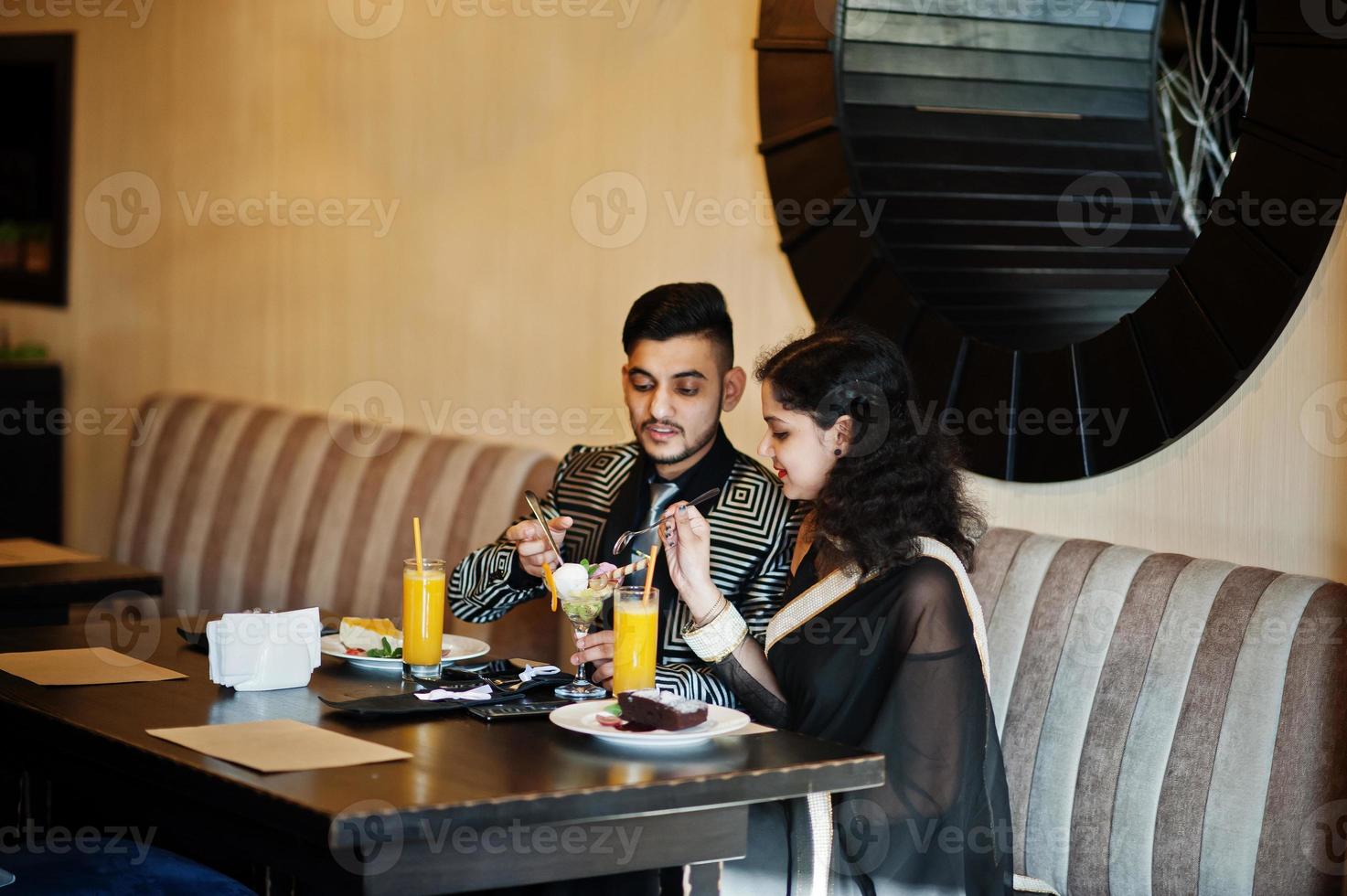 schönes indisches verliebtes paar, trägt saree und eleganten anzug, posiert im restaurant. foto