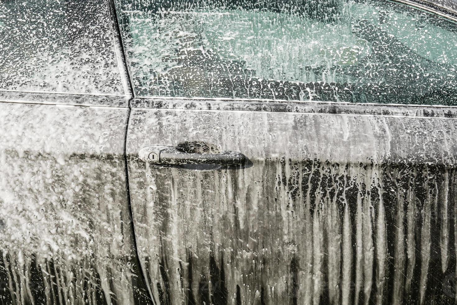 Waschen des Autos mit Schaum aus nächster Nähe foto