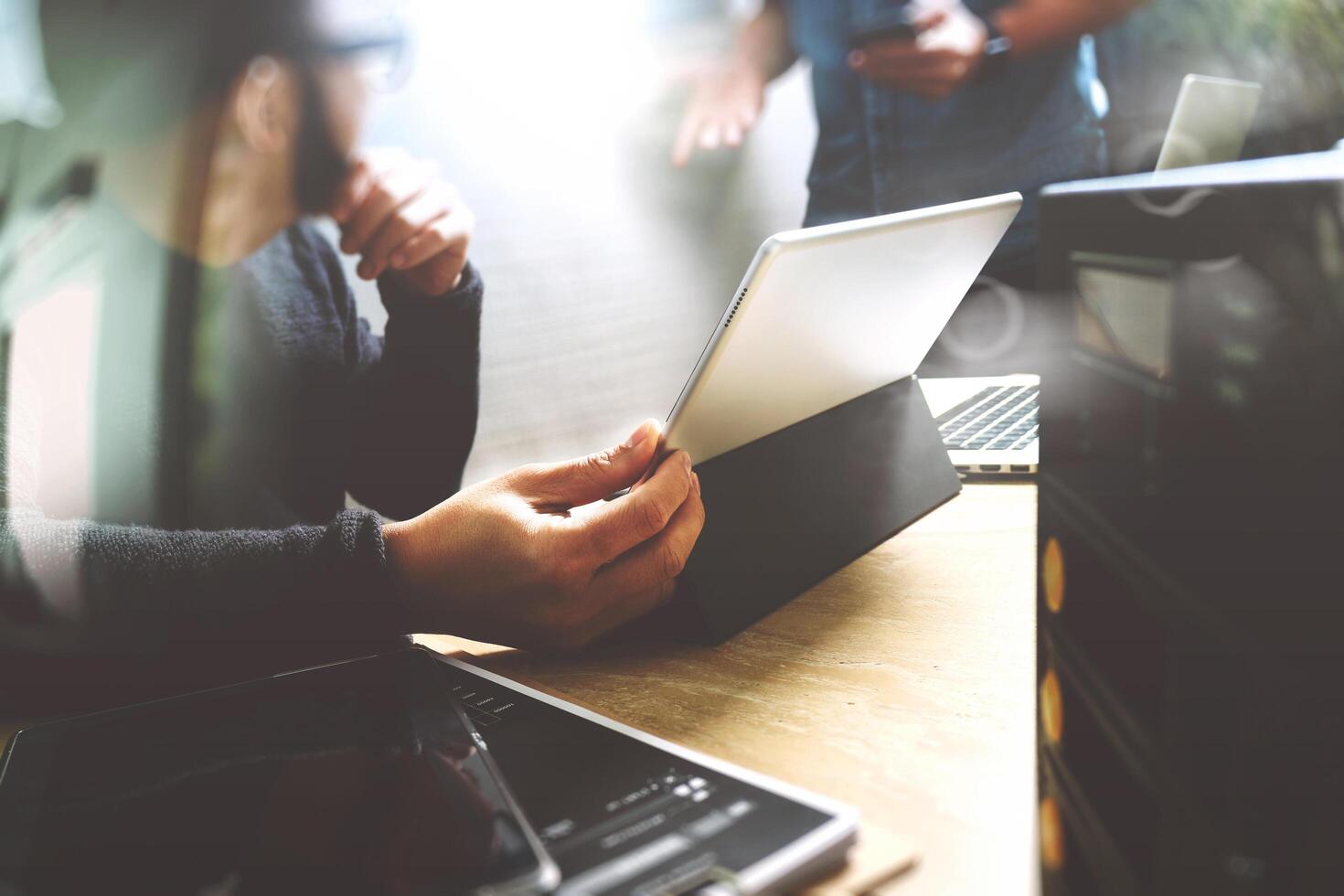 Startup-Programmierteam. website-designer, der digitale tablet-dock-tastatur und computer-laptop mit smartphone und kompaktem server auf mable schreibtisch, lichteffekt arbeitet foto