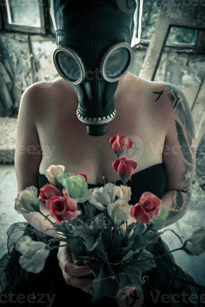 Frau in Gasmaske mit Blumen foto