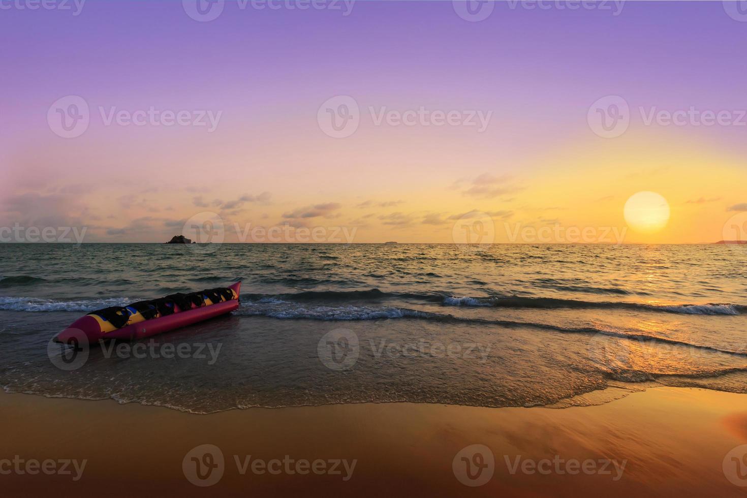 Bananenboot am Strand bei Sonnenuntergang foto