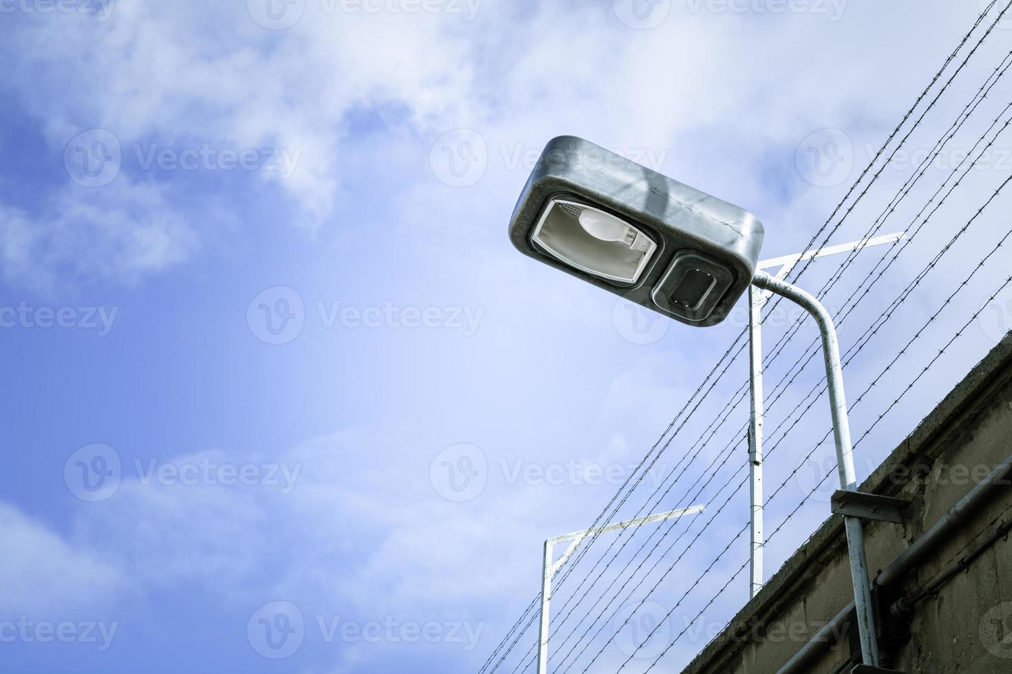 Sicherheitslicht an einer Umfassungsmauer mit Stacheldraht foto