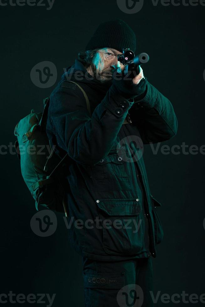 Scharfschütze mit Bart in schwarzer Haltepistole. Studioaufnahme. foto