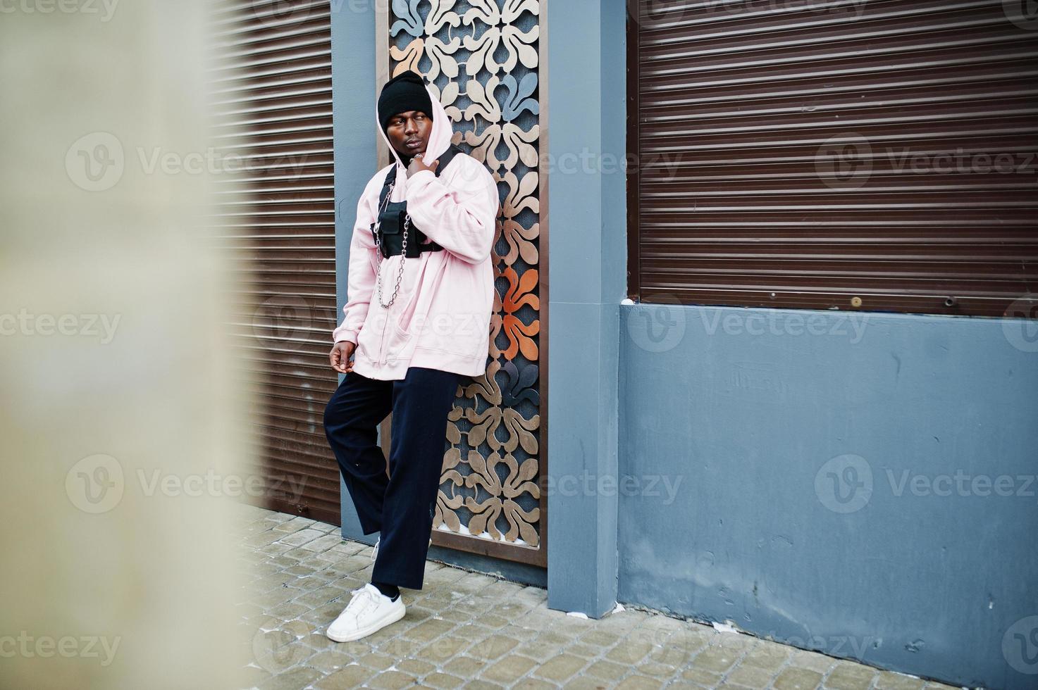 stilvoller afroamerikanischer mann im urbanen stil in rosa hoodie posiert. Afro-Rapper-Typ. foto