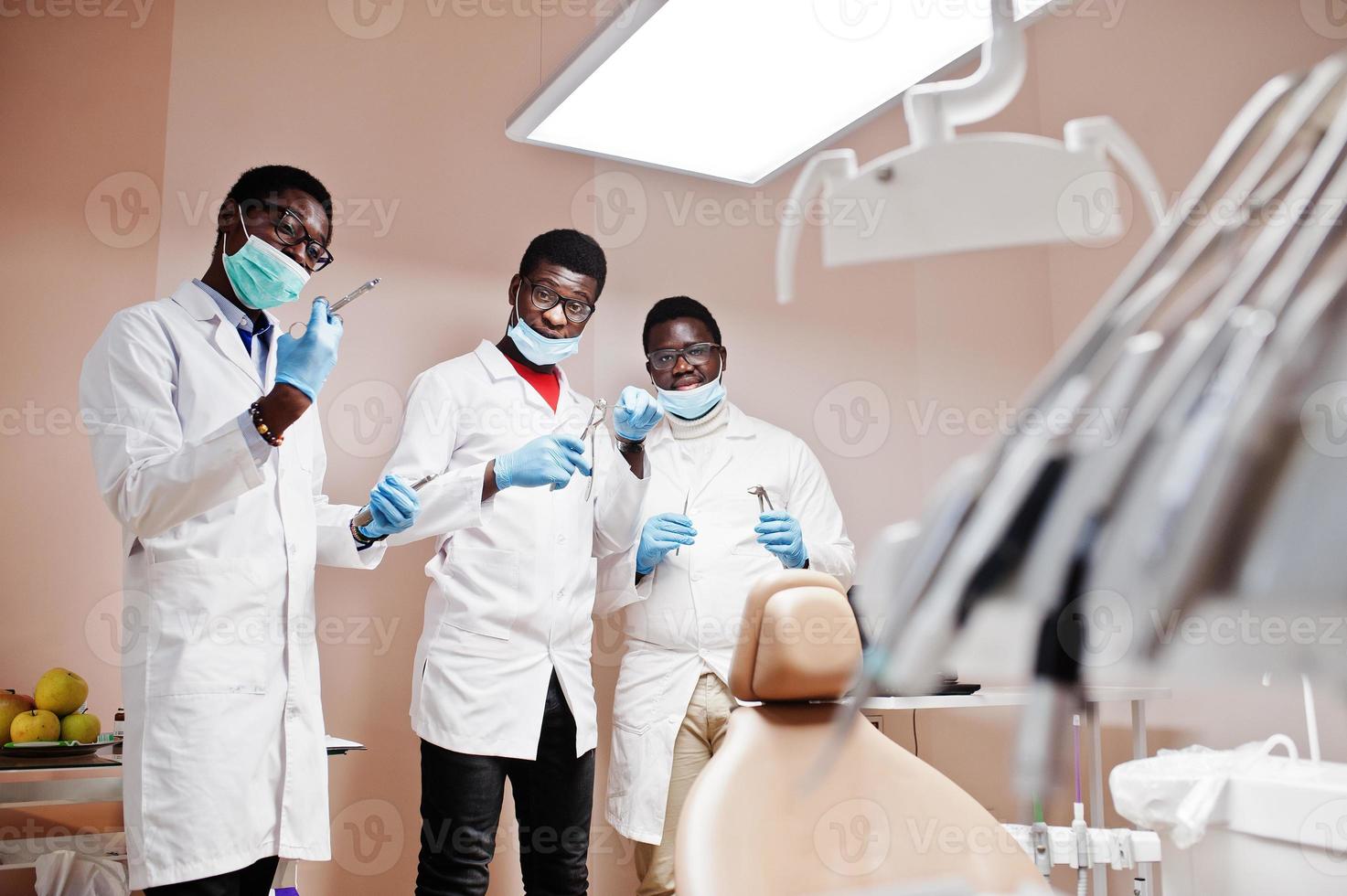 drei afroamerikanische männliche arztkollegen mit werkzeugen in der klinik. foto