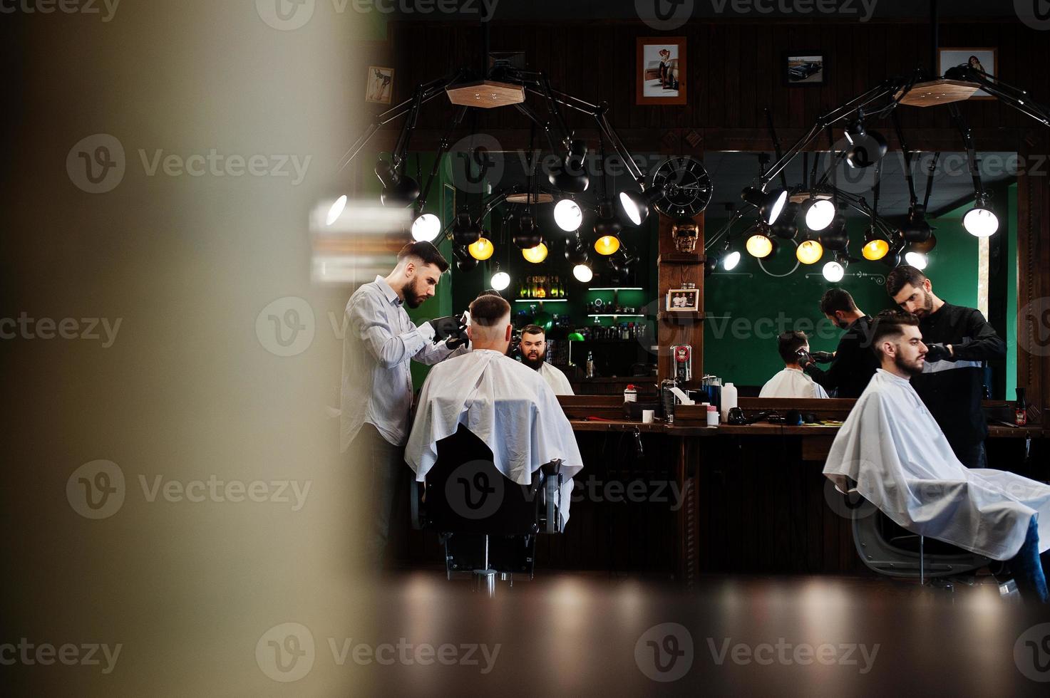 hübscher bärtiger mann im friseursalon, friseur bei der arbeit. foto