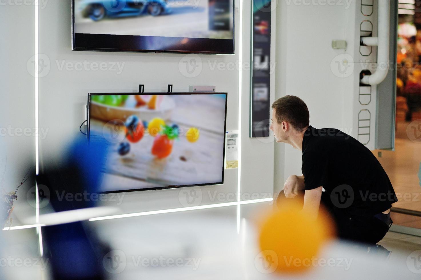 verkäufer mann professioneller berater im tech store oder shop stehen in der nähe von smart tv. foto