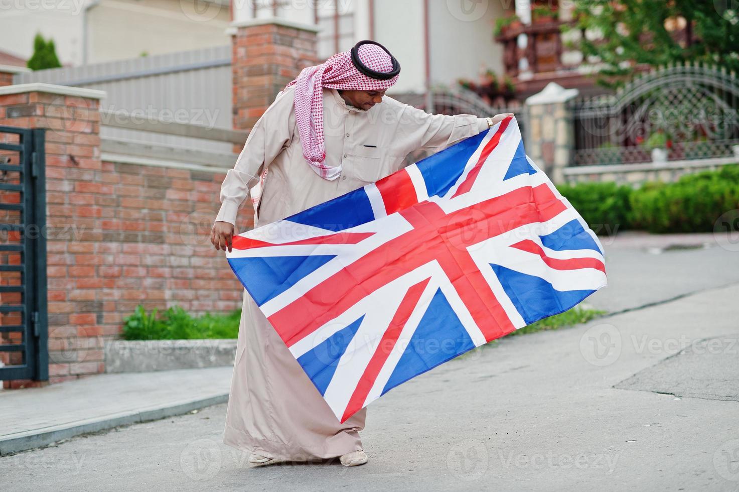 Arabischer Mann aus dem Nahen Osten posierte auf der Straße mit britischer Flagge. konzept für england und arabische länder. foto