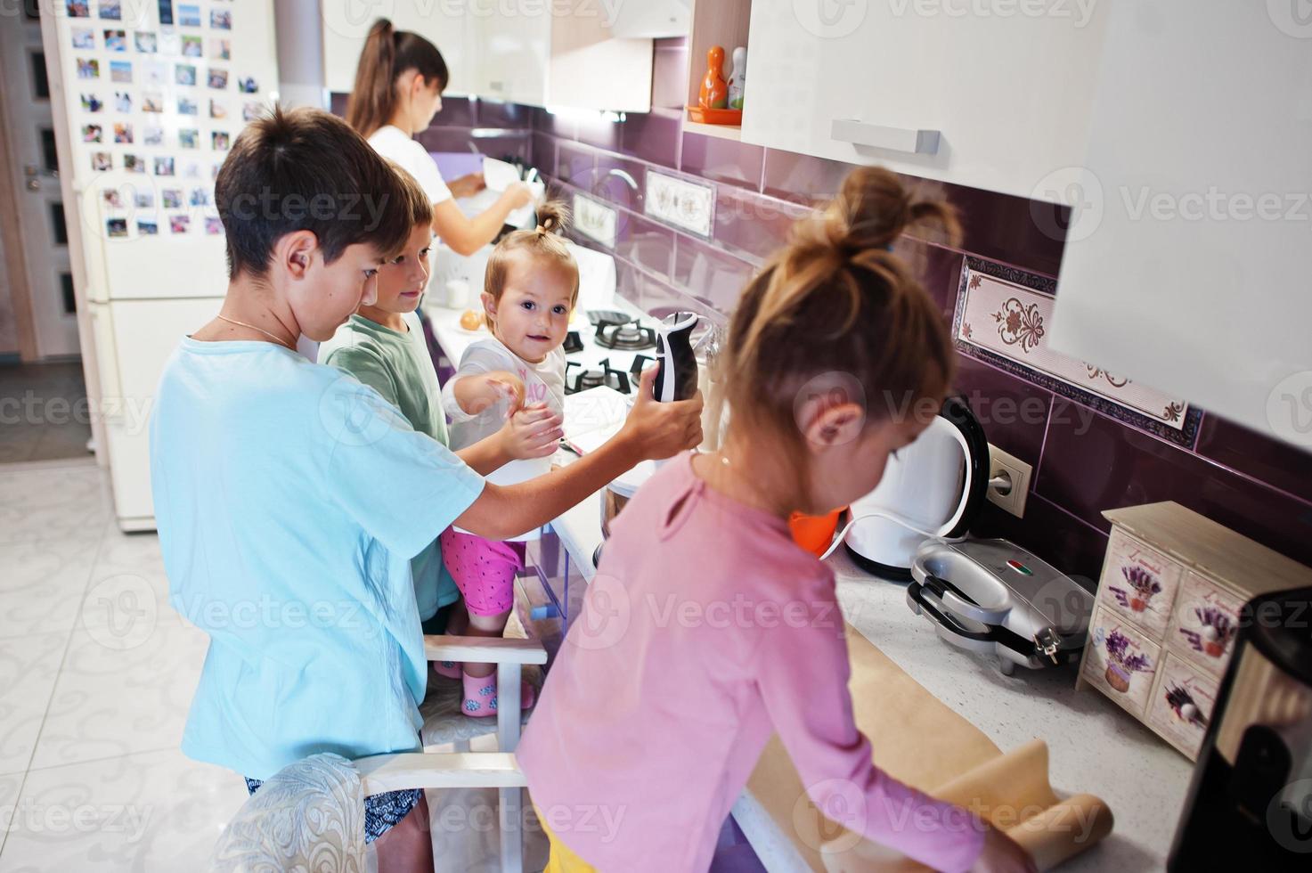 mutter mit kindern, die in der küche kochen, glückliche kindermomente. foto