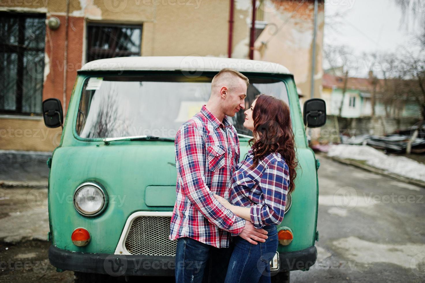 stylisches Paar auf kariertem Hemd verliebt zusammen gegen alten Minivan. foto