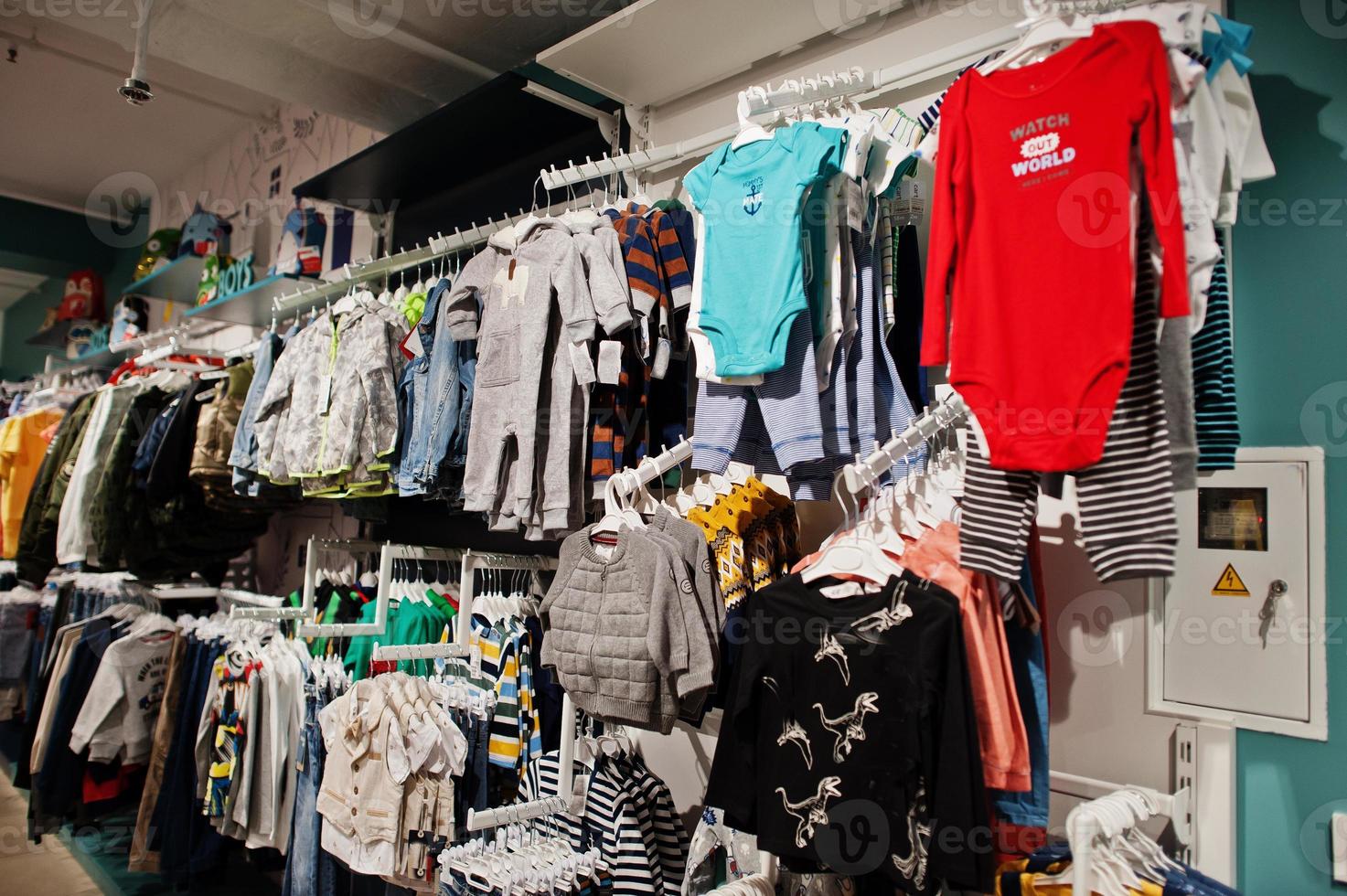 Auf der Auslage im Babybekleidungsgeschäft hängen bunte Kinderkleider. Jungenabteilung. foto