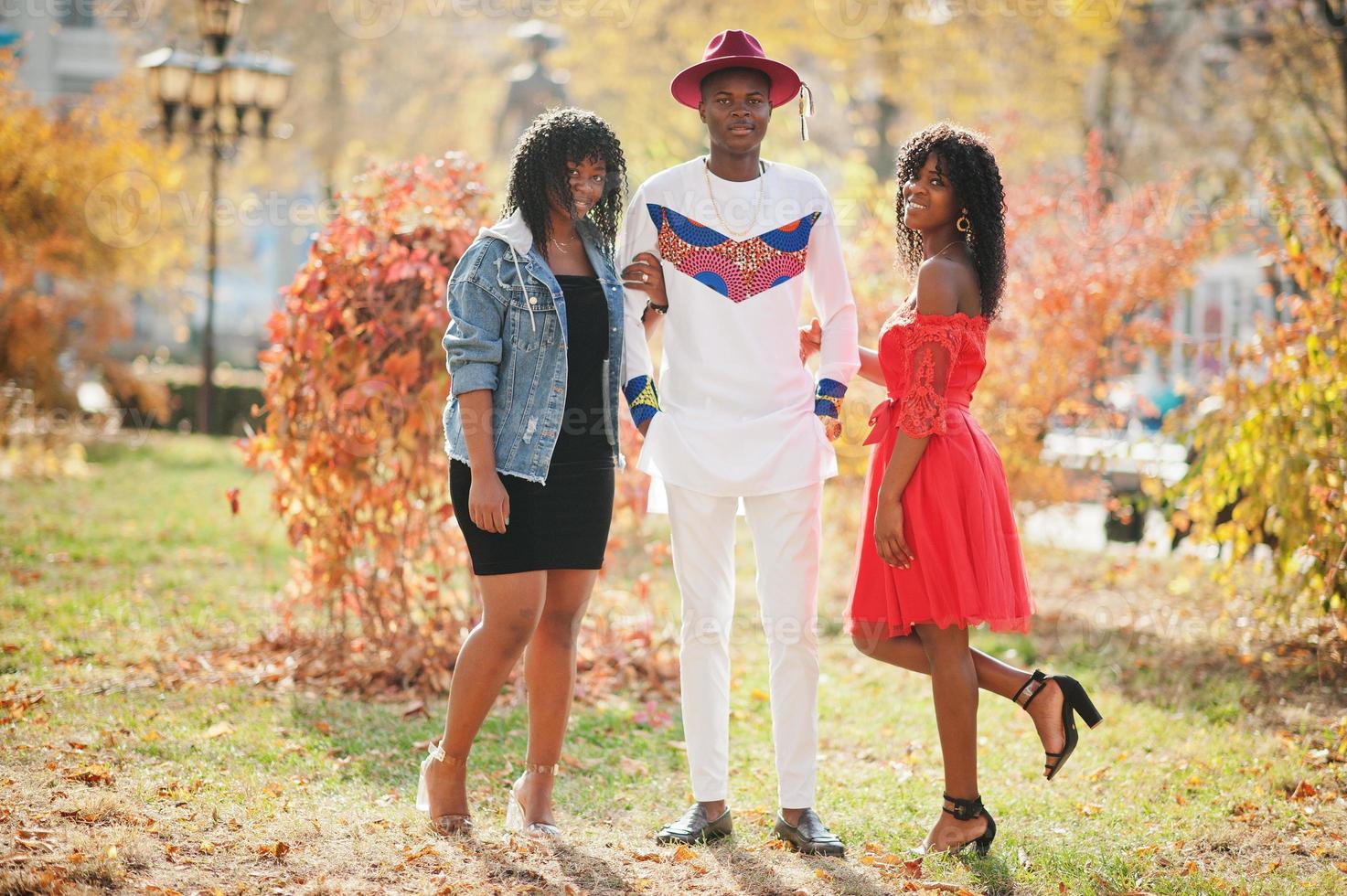 Gruppe von drei stilvollen, trendigen Afro-Frankreich-Freunden posierte am Herbsttag. schwarzafrikanisches Mannmodell mit zwei dunkelhäutigen Frauen. foto