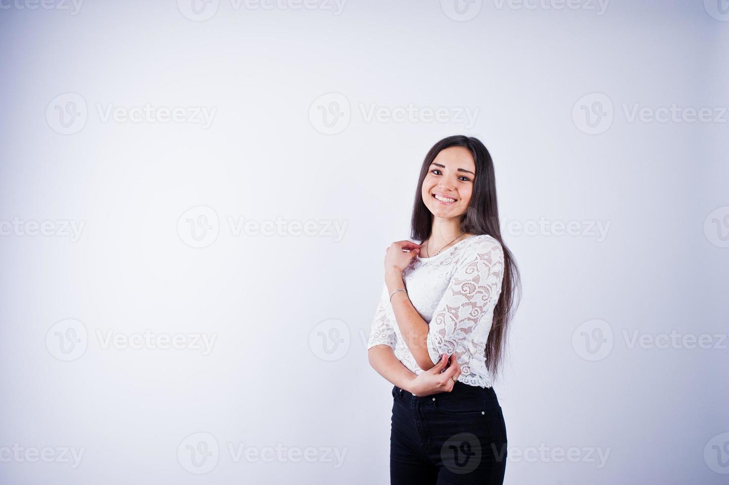 Porträt einer eleganten jungen Frau in weißem Oberteil und schwarzer Hose im Studio. foto