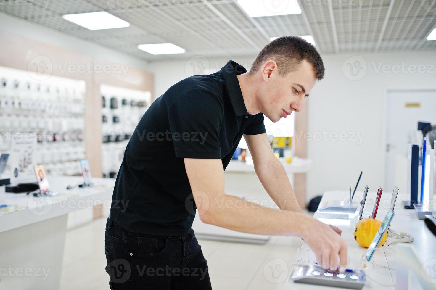 verkäufer mann handy professioneller berater im tech store oder shop hält neues smartphone zur hand. foto