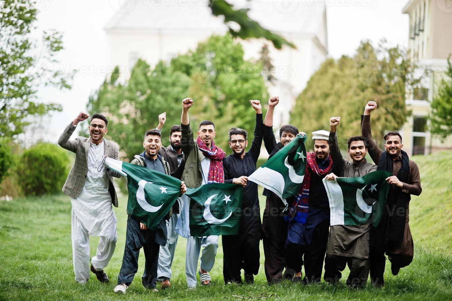 Gruppe pakistanischer Männer, die traditionelle Kleidung Salwar Kameez oder Kurta mit pakistanischen Flaggen tragen. foto