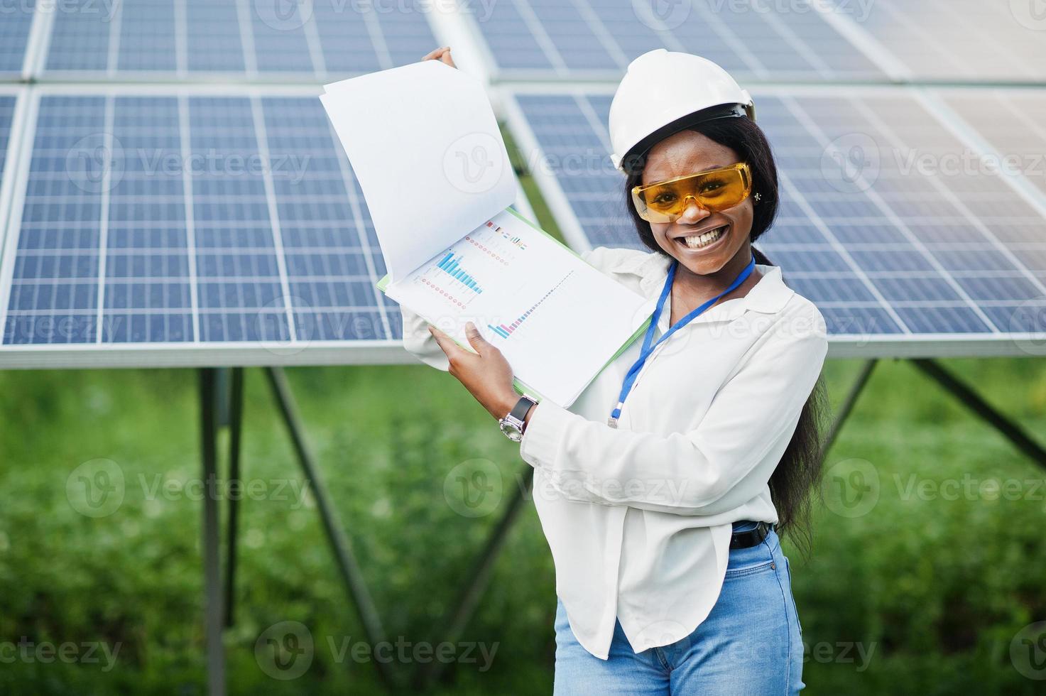 afroamerikanischer techniker überprüft die wartung der sonnenkollektoren. Schwarze Ingenieurin an der Solarstation. foto