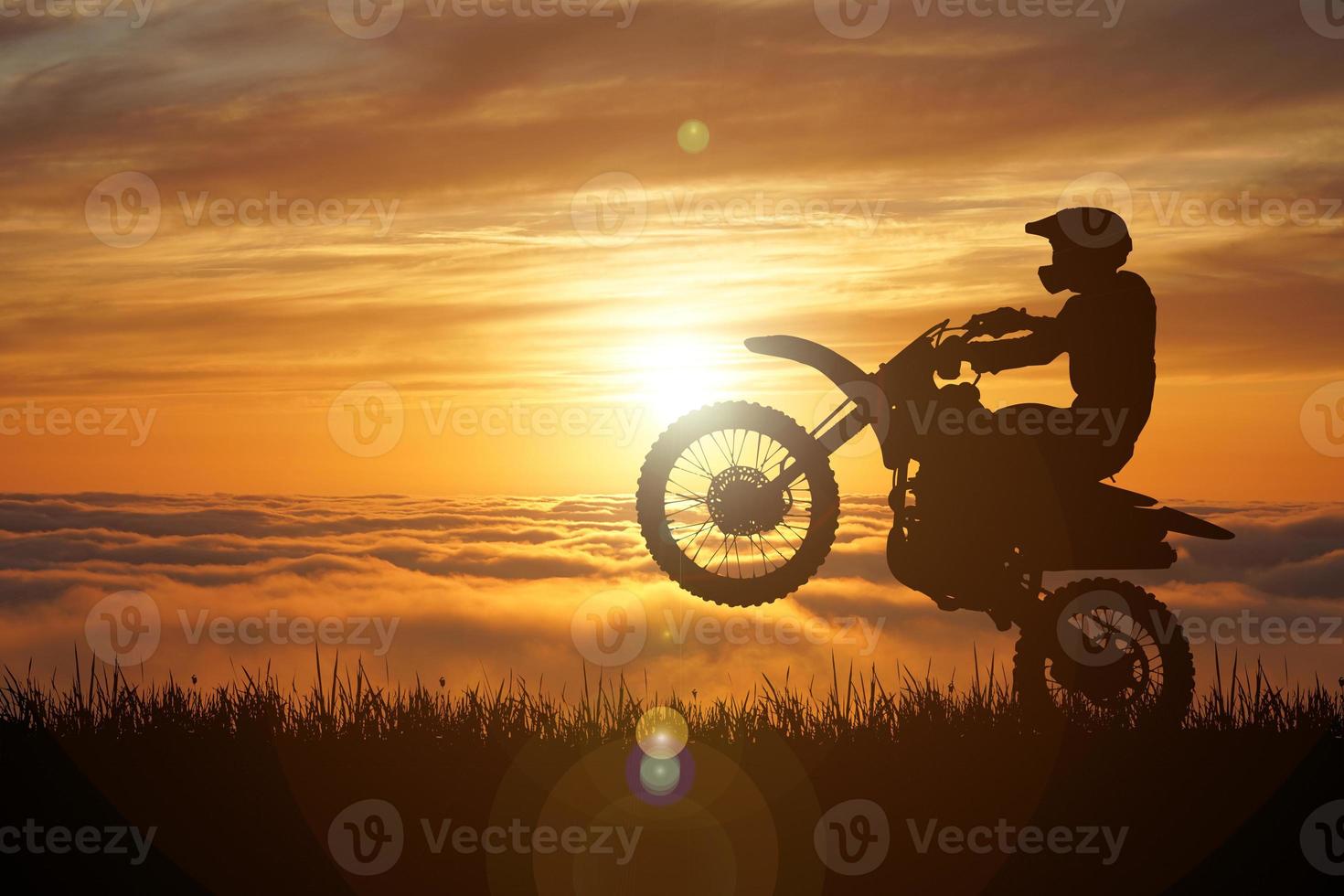 Silhouette eines Motocross-Motorrads, das das Vorderrad anhebt. Abenteuer- und Aktionskonzepte foto