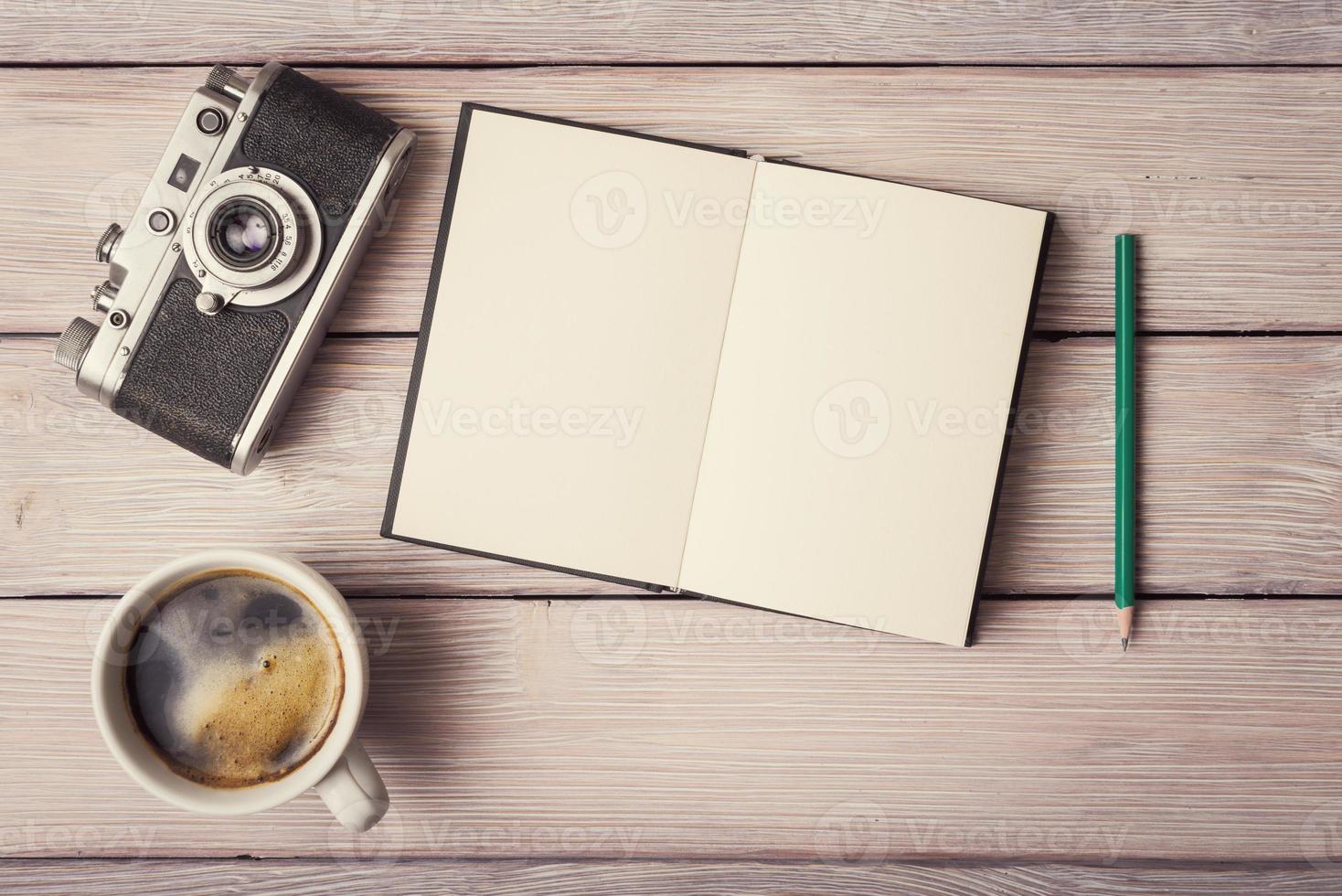 Retro-Kamera, offenes Notizbuch und eine Tasse Kaffee foto