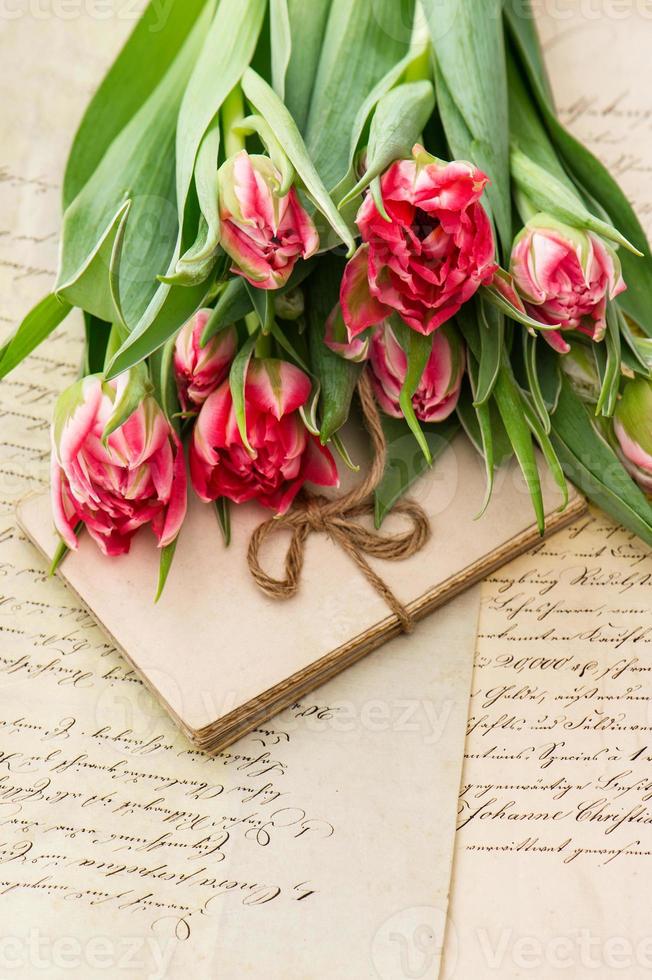 zarte rosa Tulpen, alte Liebesbriefe und Karten foto