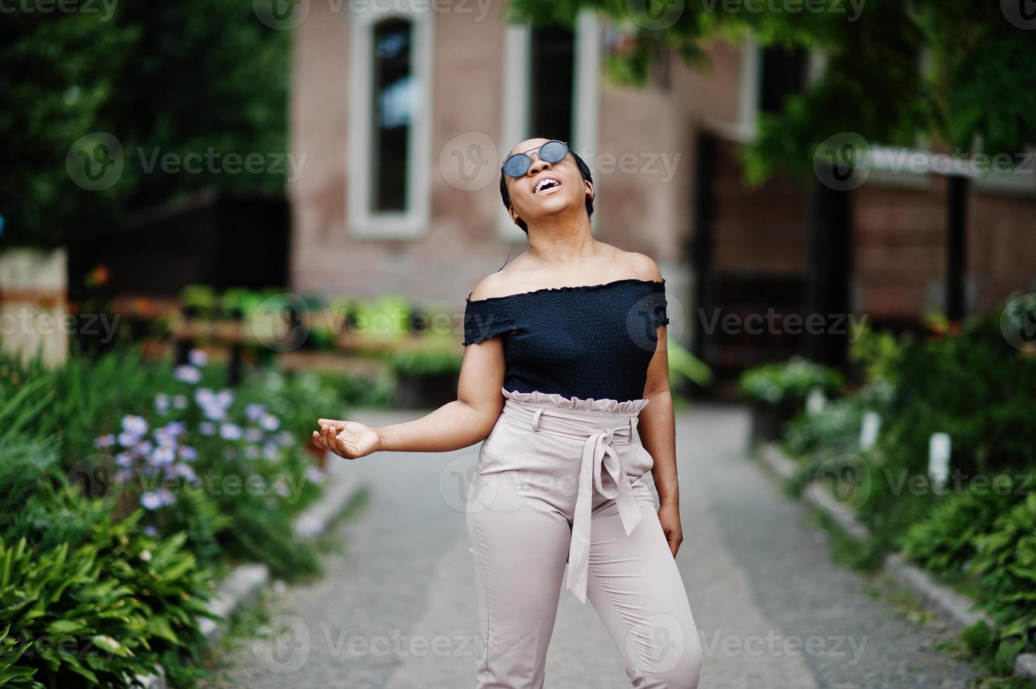 stilvolle afrikanisch-amerikanische Frau mit Sonnenbrille posierte im Freien. foto