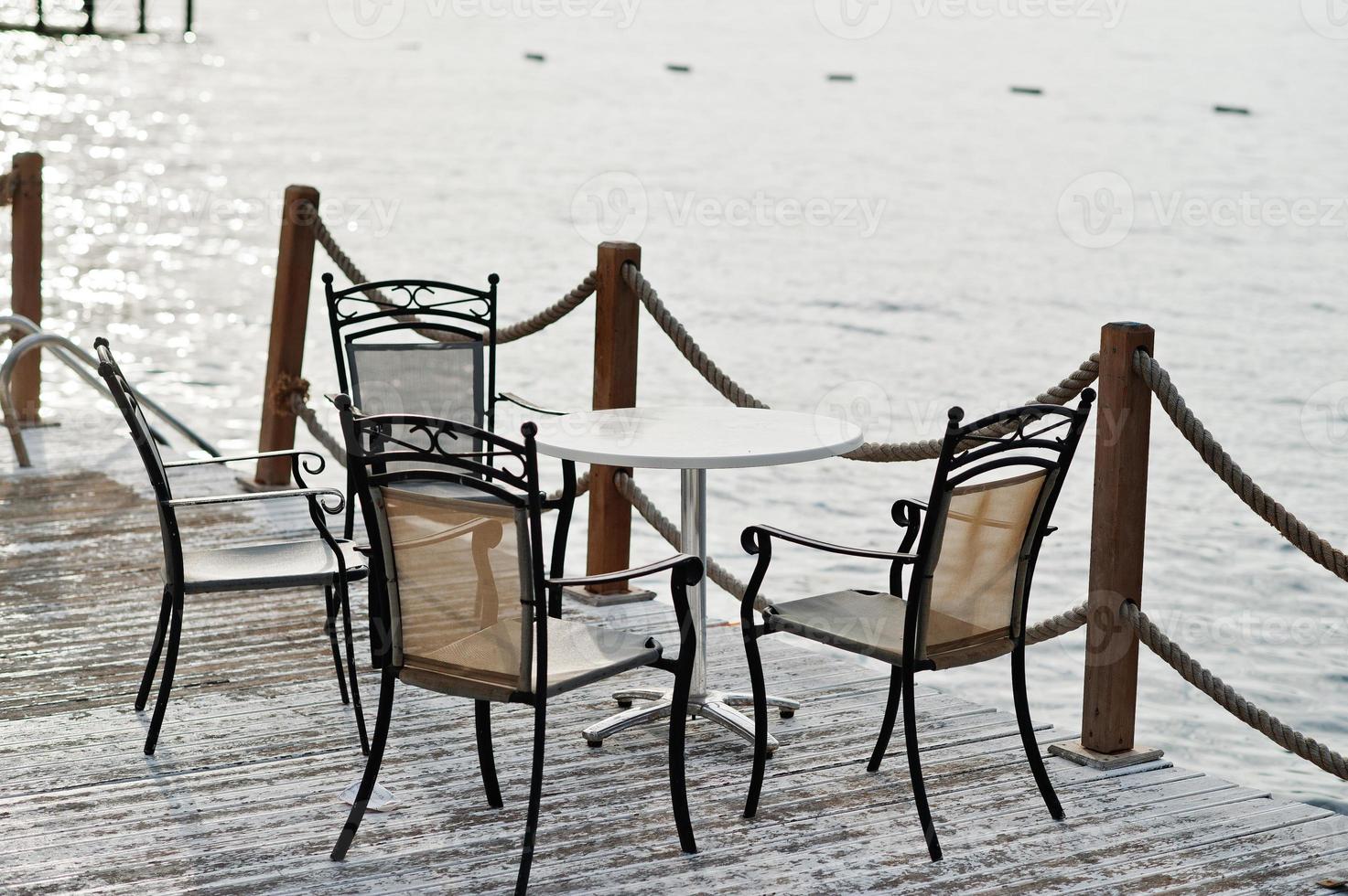 Geländer auf Seeseil und Holz mit Tisch und Stühlen am türkischen Mittelmeer. foto