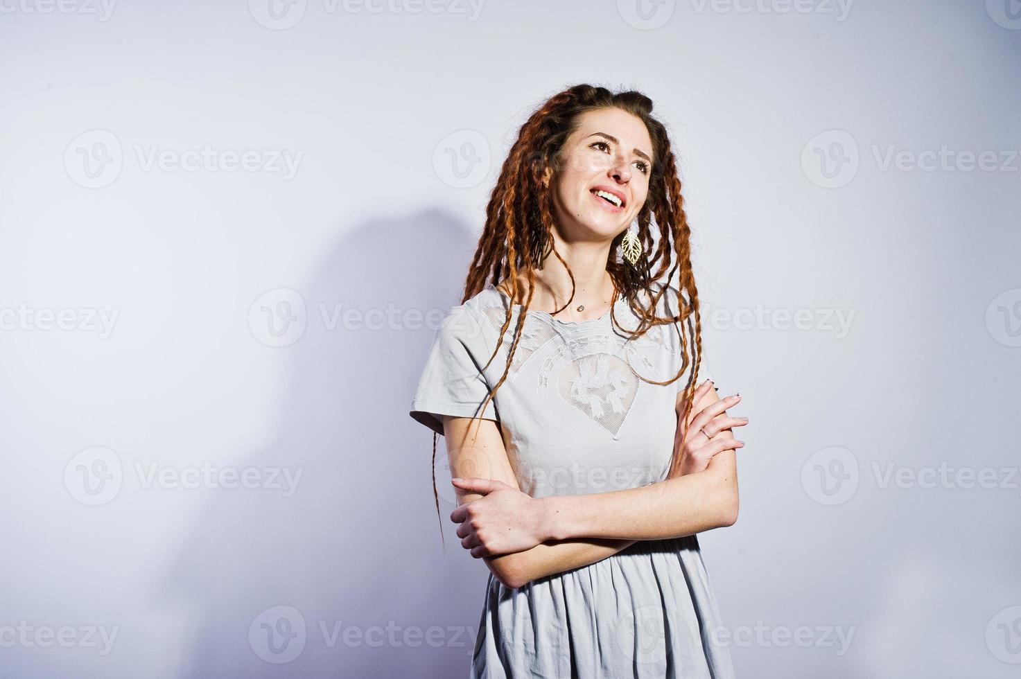 Studio-Shooting von Mädchen im grauen Kleid mit Dreads auf weißem Hintergrund. foto