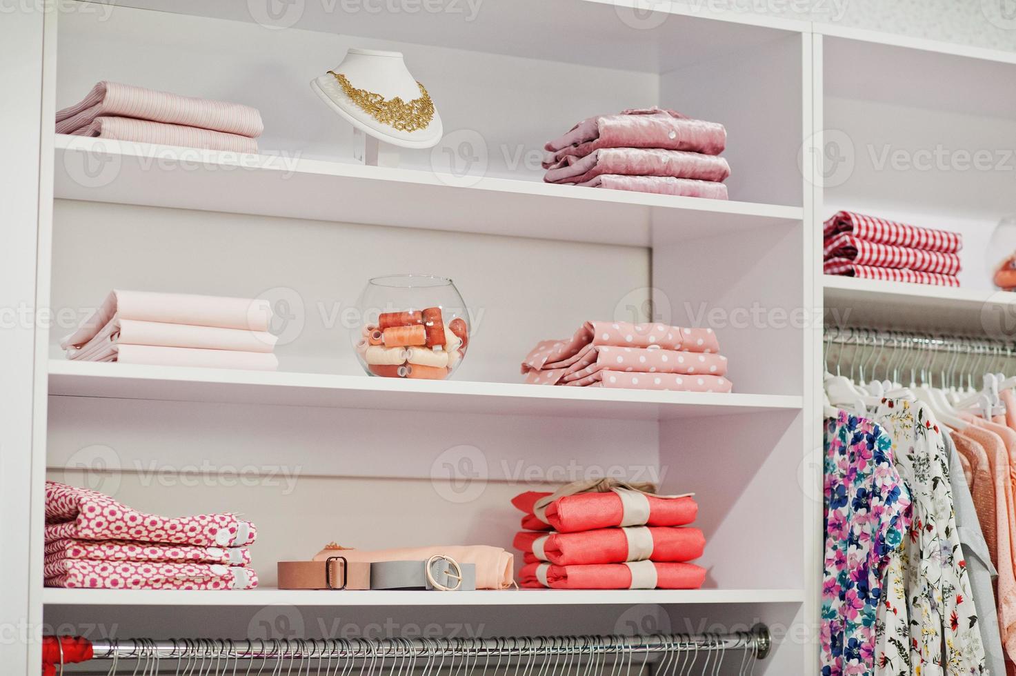 weibliches rosafarbenes buntes kleidungsset auf den regalen und regalen in der brandneuen modernen boutique des bekleidungsgeschäfts. Frühlings- und Sommerkleiderkollektionen. foto