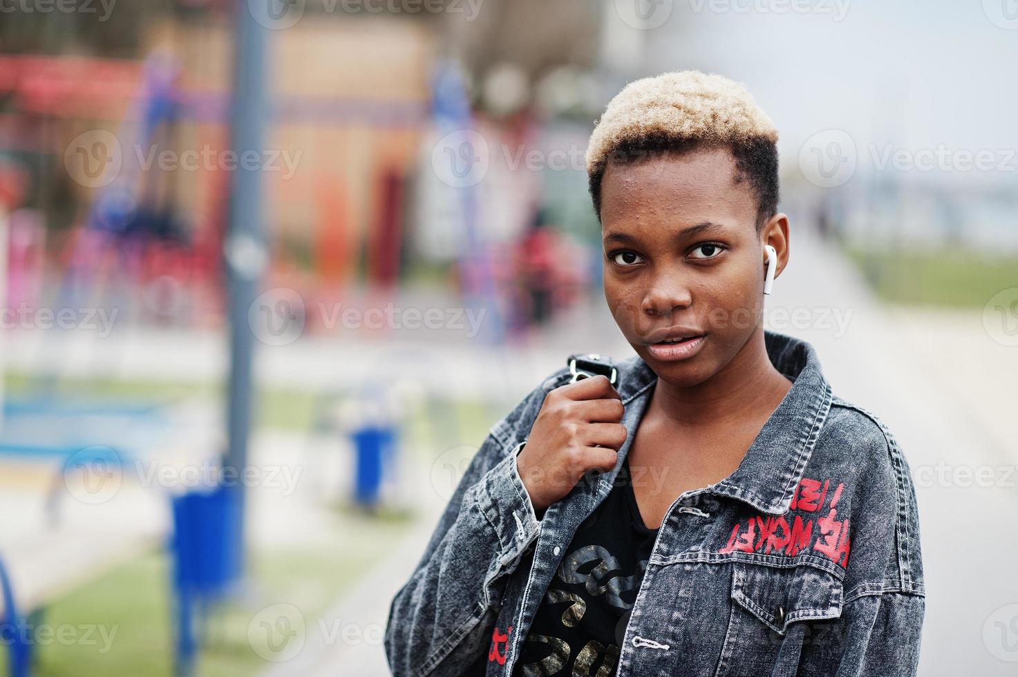 junges tausendjähriges afroamerikanisches Mädchen in der Stadt. glückliche schwarze frau mit drahtlosen kopfhörern. generation z-konzept. foto