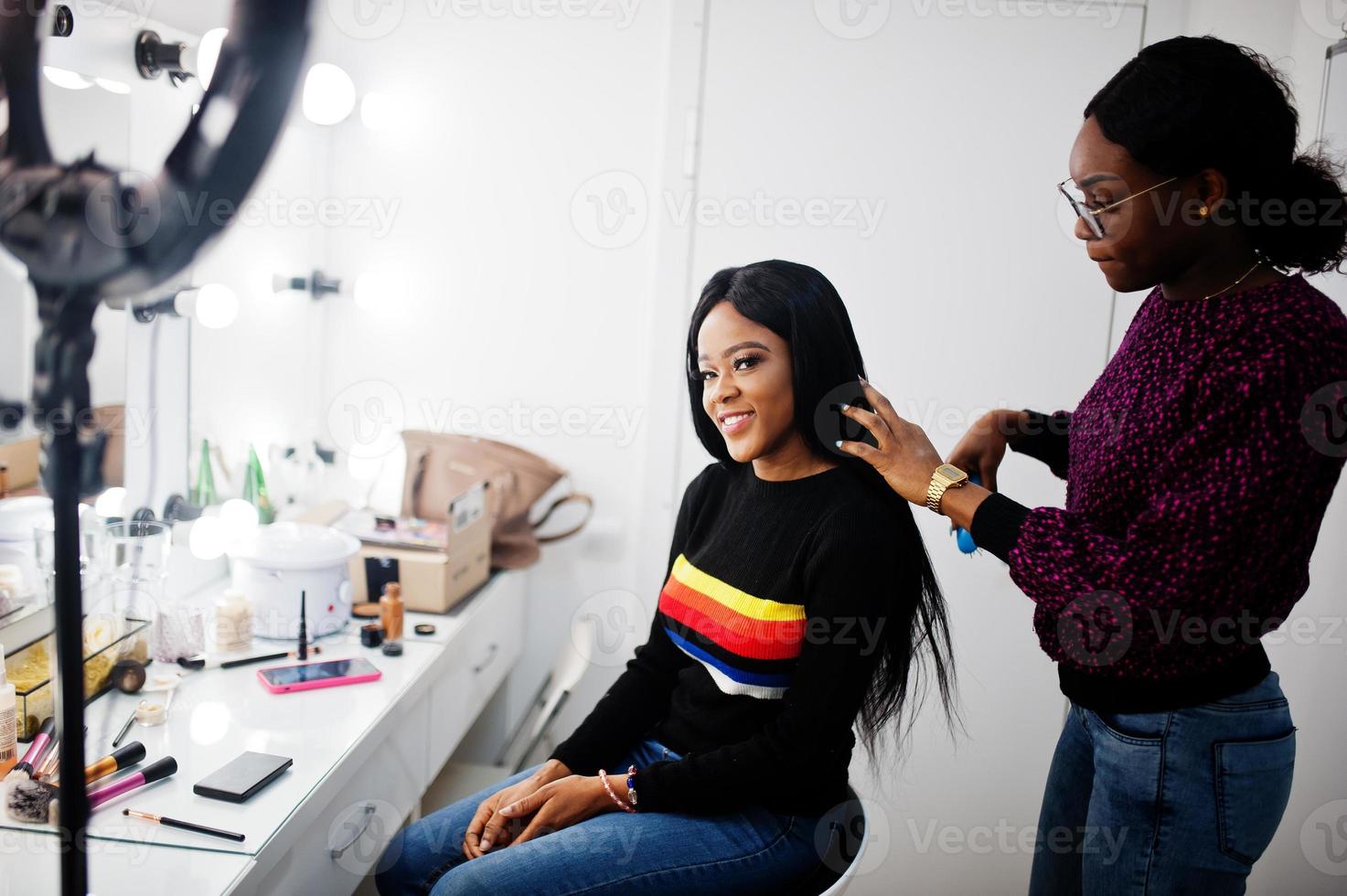 afroamerikanerin, die friseur oder friseur im schönheitssalon anwendet. foto