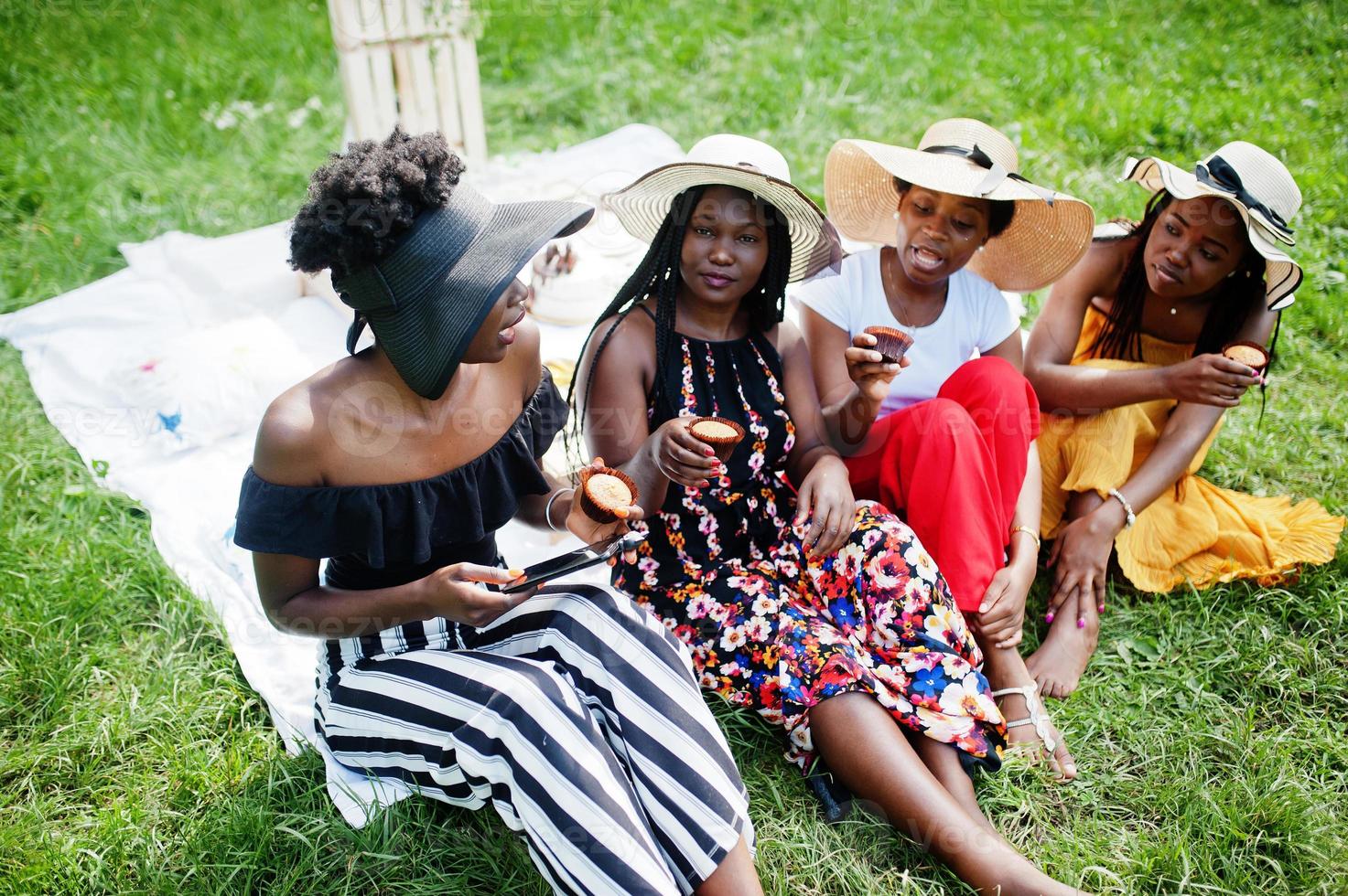 gruppe afroamerikanischer mädchen, die geburtstagsfeier feiern und muffins im freien mit dekor essen. foto